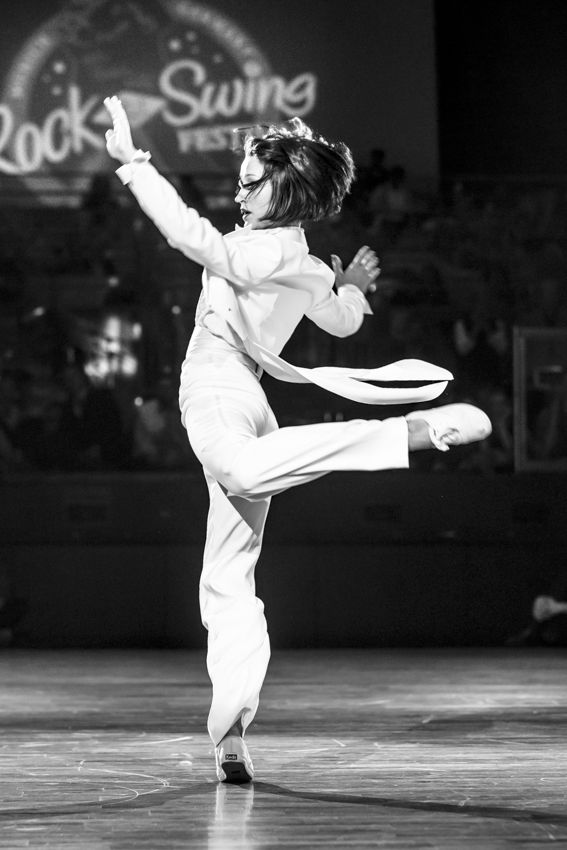 photo of Ksenia Parkhatskaya performing at a swing event in a white suit